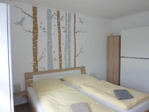 a bedroom with a bed with trees on the wall at Ferienwohnung Edelmann in Markersbach