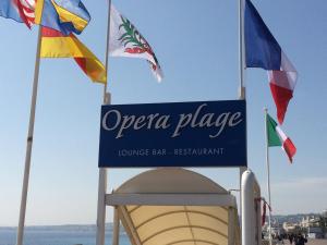 a sign for opera palace with flags in the background at Hotel Suisse in Nice