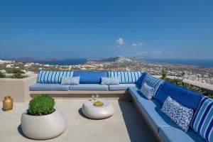 a blue couch on a balcony with a view of the ocean at Halcyon Days Suites in Pyrgos