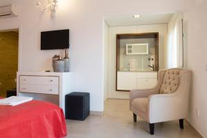 1 dormitorio con 1 cama, 1 silla y TV en Quinta do Louro, en Palmela