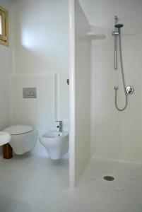 a white bathroom with a toilet and a sink at casa Namaste in Porto Columbu - Perdʼe Sali +30 photos