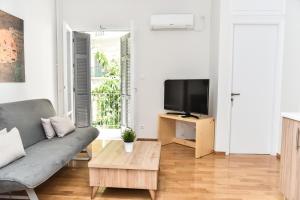 Warm Apartment at Exarchia 1 bed 2 pers في أثينا: غرفة معيشة مع أريكة وتلفزيون