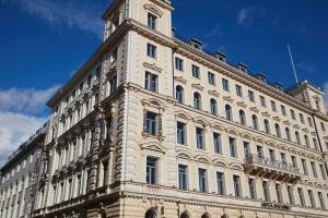 ein großes Gebäude mit einem Uhrturm darüber in der Unterkunft Hotel St. George Helsinki in Helsinki