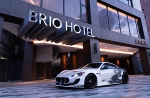 ein weißes Auto, das vor einem Gebäude parkt in der Unterkunft Brio Hotel in Kaohsiung