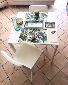 a white table and a white chair and a table and a table at B&B A casa di Rosi in Porto Recanati