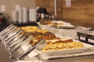un buffet con un montón de pasteles en una mesa en Impar Suites Barao de Cocais en Barão de Cocais