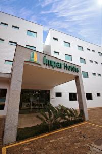 a building with a sign on the front of it at Impar Suites Barao de Cocais in Barão de Cocais