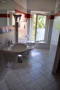 a bathroom with a sink and a toilet and a window at Ostello Residenza Molinatto in Oggiono +37 photos