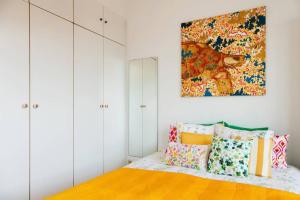 um quarto com armários brancos e uma cama com almofadas coloridas em Lovely View Ensuite Room em Bruxelas