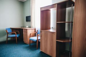 a room with a cabinet and a desk with chairs at Nikotel Hotel Mykolaiv in Mykolaiv