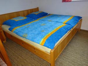 a bed with a blue comforter and blue sheets at Bungalows Raschun Grabelsdorf Etruskerweg 10 A-9122 St.Kanzian in Grabelsdorf