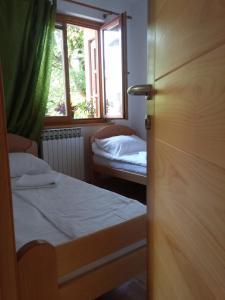 a small room with two beds and a window at ABAGuesthouse in Sarajevo
