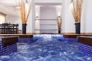 a pool of water in a room with blue tiles at Apartamentos Mexico in Vera