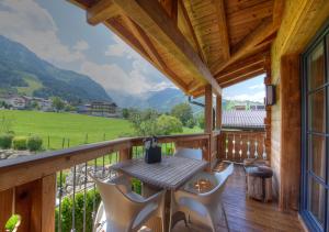 weranda ze stołem i krzesłami na balkonie w obiekcie Kaprun Mountain Resort by Kaprun Rentals w Kaprunie
