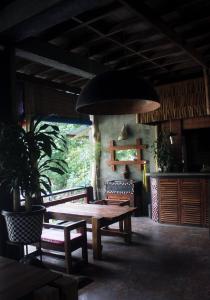 uma sala de jantar com uma mesa de madeira e cadeiras em Waterstone Guesthouse em Bukit Lawang