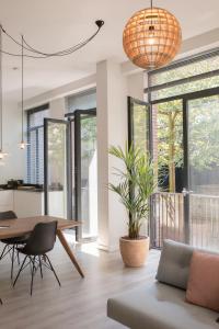 uma sala de jantar e sala de estar com uma mesa e um vaso de plantas em The Duke Boutique Apartments em Den Bosch