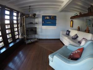 un soggiorno con divano bianco e TV di Pousada Do Capitão ad Arraial do Cabo