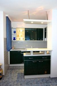 a kitchen with green cabinets and a sink at Apartment Pier in Varna City