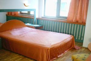 een oranje bed in een kamer met een raam bij Studio Pipo in Varna