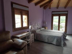 a bedroom with purple walls and a bed and a chair at Hostal los Esquiladores in Anento
