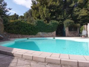 a swimming pool in a yard with a brick wall at Villa Di Tissano in Tissano