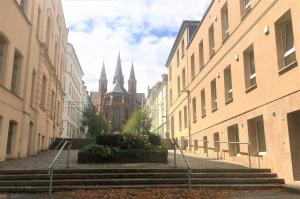 un vicolo con scale e un edificio con chiesa di Schwerin Apartment am Pfaffenteich a Schwerin