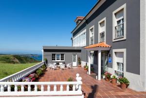 Casa con patio de ladrillo y valla blanca en Casa Maravilla en Faro de Peñas