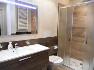a bathroom with a sink and a toilet and a mirror at Lago d'Idro - Casa Emma in Ponte Caffaro +18 photos