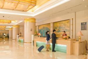 duas pessoas num balcão num aeroporto em Jiangxi Grand Hotel Beijing em Pequim