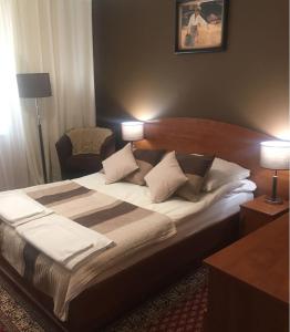 een groot bed in een hotelkamer met 2 lampen bij U Bosmana in Brodnica