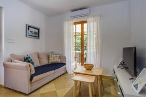 a living room with a couch and a tv at Villa Sveti Jakov in Sveti Jakov