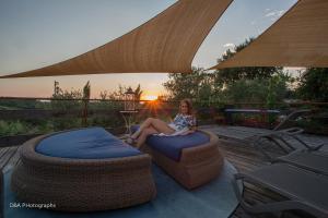 Eine Frau sitzt auf einem Sitzsack auf einer Terrasse in der Unterkunft Piccolo Feudo Green Resort only adult in Viterbo + 36 Fotos