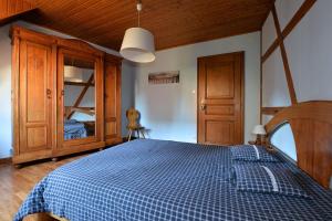 a bedroom with a bed with a blue checkered blanket at S'Harzala Bleu in Bergheim