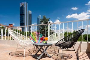 two chairs and a table with a drink on a balcony at Hotel Madrid Chamartín, Affiliated by Meliá in Madrid