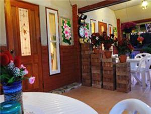 une salle à manger avec une table, des chaises et des plantes dans l'établissement Klongsai Hills, à Wang Nam Khiao
