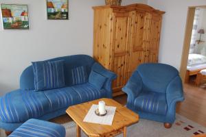 a living room with two blue chairs and a coffee table at Fewo Kuhlmann in Willingen