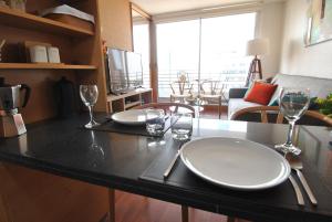 a kitchen with two plates and glasses on a counter at Costanera Stay Apartments in Santiago
