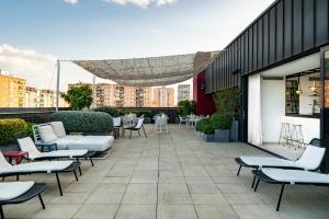 eine Terrasse mit Stühlen und Tischen an einem Gebäude in der Unterkunft Vincci Bit in Barcelona