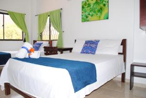 a bedroom with a bed with a blue blanket on it at Hotel Ocean Taganga Internacional in Taganga