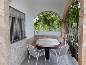 a patio with a table and chairs and a window at Casa Gudelj in Pirovac