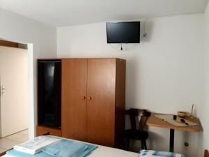 a room with a bed and a cabinet and a table at Casa Gudelj in Pirovac