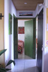 un pasillo con una puerta verde y una cama en una habitación en Ap-Art, en La Seu d'Urgell