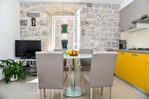 een keuken met een tafel met stoelen en een televisie bij Mila Apartment in Sinj