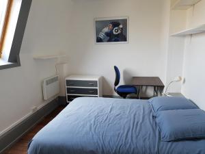 スダンにあるAppartement 3 piècesのベッドルーム(青いベッド1台、デスク付)