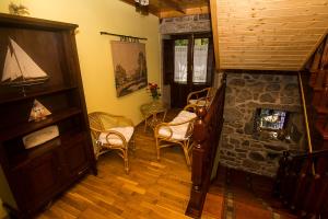 a living room with a staircase and a stone fireplace at Casal de Cereixo in Tufiones