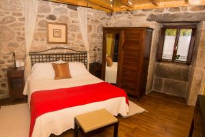 a bedroom with a large bed in a room with stone walls at Casal de Cereixo in Tufiones