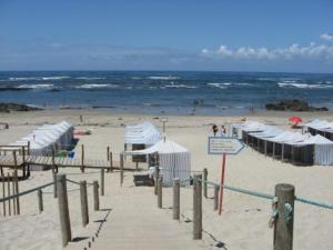 una playa de arena con sombrillas y el océano en Susanna, en Viana do Castelo