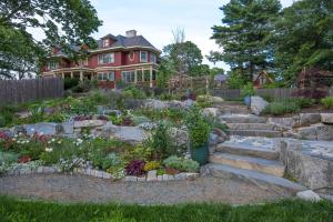 a garden in front of a red house at The Inn on Mount Desert in Bar Harbor
