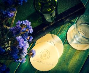 two plates and a vase of purple flowers on a table at Stone Cellars in Douma