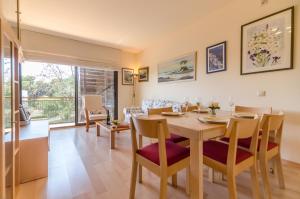 a dining room and living room with a table and chairs at Boadella - ATICO in Lloret de Mar